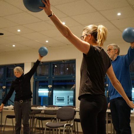 Senioren trainieren ihre Koordination mit dem Flexi Stab.